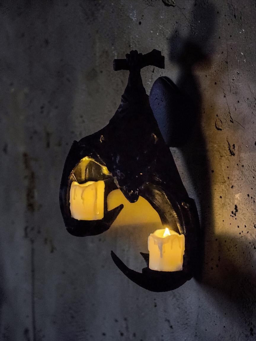 Absolute Prints matte black bat wall sconce with two glowing pillar candles for gothic home decor