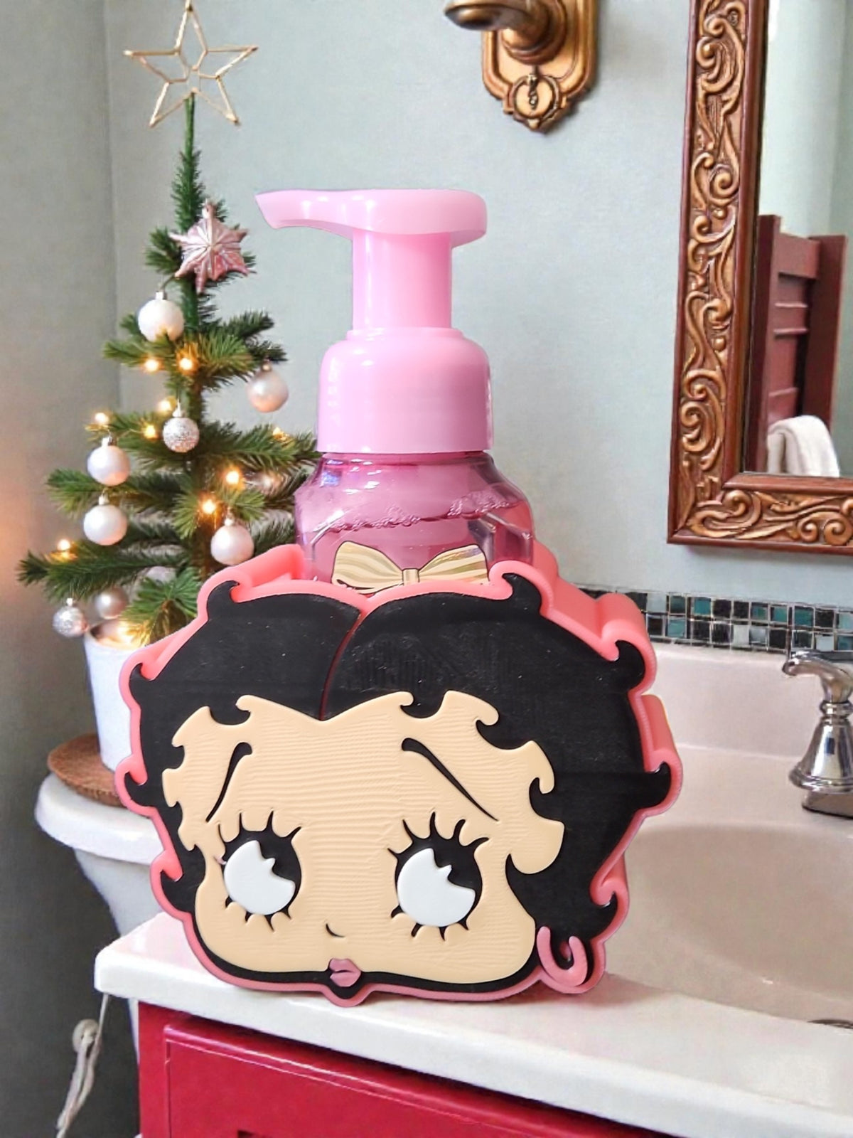 Absolute Prints Betty Boop character soap dispenser holder with pink foaming soap on a bathroom vanity