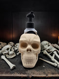 Absolute Prints bone-colored skull-shaped soap dispenser holder for foaming hand soap on a dark gothic background